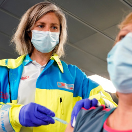 Una sanitaria vacuna a una mujer en el  WiZink Center, de Madrid. REUTERS/Juan Medina