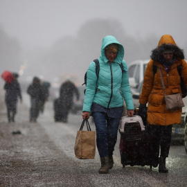 Las personas que huyen de la invasión rusa de Ucrania se dirigen hacia el cruce fronterizo de Shehyni, Polonia.