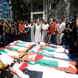 15/05/2021. Varias personas se acercan a los cadáveres de los palestinos asesinados este sábado por las fuerzas israelíes. - Reuters