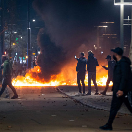 La gente se para cerca de objetos en llamas después de que una protesta  en Róterdam contra la 'política 2G' se convirtiera en disturbios