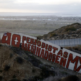 Una pintura que dice "140 periodistas asesinados en MX" en una sección de la valla fronteriza entre EE. UU. y México en Tijuana, en el estado de Baja California, México, en 2018