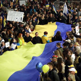 Gente protesta con una larga bandera ucraniana contra la invasión rusa de Ucrania y en apoyo de Ucrania, en Tel Aviv