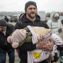 05/03/2022 Un hombre sostiene a un bebé en brazos en el paso fronterizo de Porubne, en el oeste de Ucrania