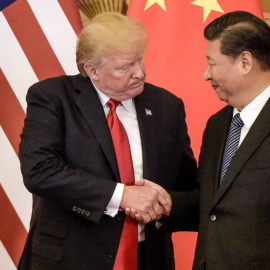Donald Trump, a la izquierda, estrechando la mano del líder chino, Xi Jinping - FRED DUFOUR/AFP