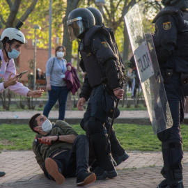 El periodista Guillermo Martínez, en el suelo junto a dos policías antidisturbios, el 7 de abril de 2021, día del mitin de Vox en Vallecas