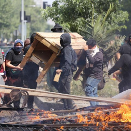 Manifestantes queman objetos durante una protesta contra el incremento del precio en los billetes del metro, este sábado en Santiago (Chile). Durante la semana, las protestas por el incremento del precio del billete del metro de Santiago de Chile fueron 