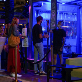Un empleado toma la temperatura a un joven que hace cola para entrar en un pub en el puerto deportivo de Marbella. Fotografía de archivo.