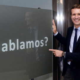 El candidato a la Presidencia del PP Pablo Casado posa junto una publicidad de un establecimiento comercial, en el que se puede leer “¿Hablamos?”. EFE/Nacho Gallego