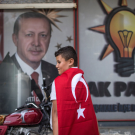 Un niño con una bandera turca frente a un retrato del presidente Recep Tayyip Erdogan cerca de la frontera siria, en el Sanliurfa, el distrito de Akcakale. EFE / EPA / ERDEM SAHIN
