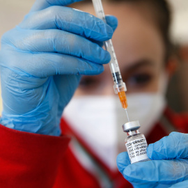 Un trabajador de la salud utiliza una jeringa para extraer una dosis de la vacuna Pfizer / BioNTech COVID-19.