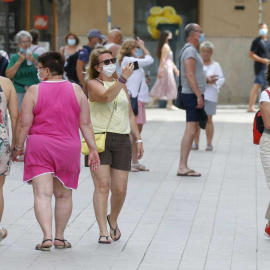 Varias personas andando por una calle.