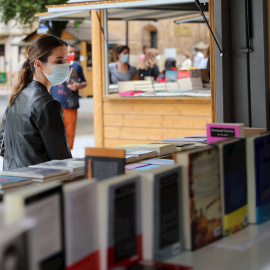 Una mujer con mascarilla este sabado en la feria del libro de Oviedo.