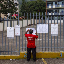 Un hombre busca su nombre en las hojas del padrón electoral a la entrada de un colegio electoral durante las elecciones regionales y municipales en Caracas, el 21 de noviembre de 2021.