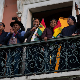 El presidente boliviano Luis Arce saluda a sus seguidores desde el balcón del Palacio de Gobierno, después de que soldados tomaran la plaza en un intento de golpe de Estado.