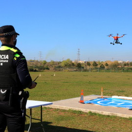 Un agent de la Guàrdia Urbana de Tarragona fent aterrar el dron del cos policial durant una demostració a Campclar. 24 de març del 2021.