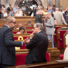 El presidente de la Generalitat de Cataluña, Quim Torra (d) y el conseller de Interior, Miquel Buch (i), esperan el inicio del pleno en el Parlament mientras la mesa continúa reunida para abordar el informe de los servicios jurídicos sobre el alcance d