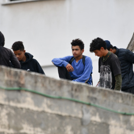 Varios menores migrantes, en el tejado de una nave industrial, a 27 de agosto de 2021, en Ceuta.