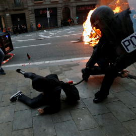 Un agente de la Policía Nacional golpe a un manifestante. / Reuters