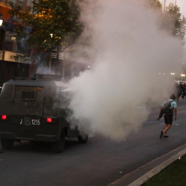 Carabineros de Chile rocía a los manifestantes con gas lacrimógeno este viernes en el marco de las protestas contra el alza del billete de Metro, en el centro de Santiago (Chile). Las protestas por el alza del precio del tiquete del Metro de Santiago se