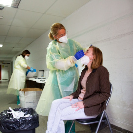 Una sanitaria realiza un test de antígenos o una PCR a una mujer, en un dispositivo de cribado masivo instalado en el Hospital Perpetuo Socorro, en Badajoz, Extremadura (España), a 1 de abril de 2021.
