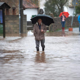 23/10/2019.- Un hombre camina por el agua que inunda Virgen de la Peña en Cantabria. EFE/Pedro Puente Hoyos