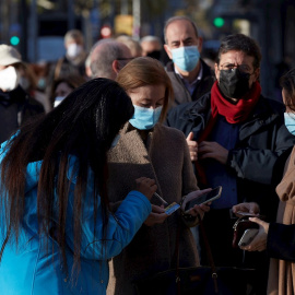Varias personas hacen cola para vacunarse ante la sede de Casa Seat en Barcelona, uno de los puntos de vacunación fijos donde el Departamento de Salud ha retomado este lunes la estrategia de vacunación con dos vehículos adaptados para uso sanitario est