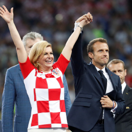 Emmanuel Macron levanta la mano de la presidenta de Croacia Kolinda Grabar-Kitarovic. REUTERS