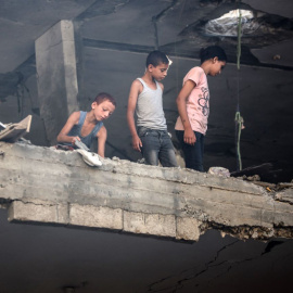 Varios niños palestinos miran los daños tras un ataque israelí en el campo de refugiados de Nuseirat, a 13 de julio de 2024.