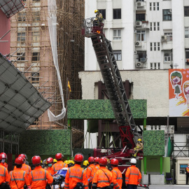 Los bomberos despliegan una escalera para rescatar a las personas atrapadas en el incendio en el World Trade Center en Hong Kong.