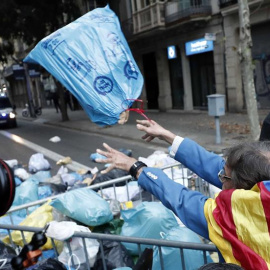 Manifestantes arrojan bolsas de basura a la Delegación del Gobierno durante las protestas en Barcelona. / JESÚS DIGES (EFE)
