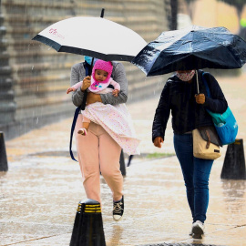Personas se resguardan de la lluvia este miércoles.