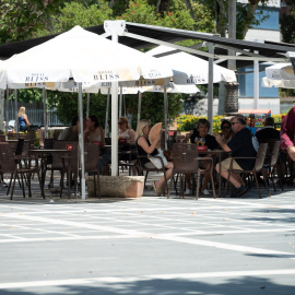 16/07/2024 Una persona mayor camina junto a una terraza en Badajoz (Extremadura). Foto de archivo.