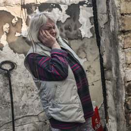 Una mujer observa el estado de su vivienda tras sufrir los efectos de un bombardeo en el barrio de Shevchenko, en Kiev, este miércoles. Aris Messinis/AFP