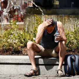 Un hombre se echa agua por la cara durante la ola de calor en Madrid.