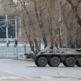 Un miembro del servicio kazajo camina cerca de un transporte blindado tras las protestas provocadas por el aumento del precio del combustible en Almaty, Kazajistán, el 7 de enero de 2022.