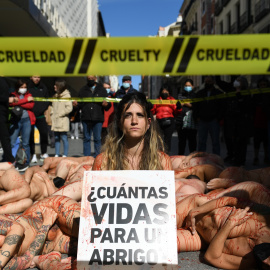 Varias chicas desnudas con pintura roja sobre el cuerpo, con una pancarta que reza '¿Cuántas vidas para un abrigo?' en la protesta contra la industria peletera ‘Sin Piel 2022’, en la calle Preciados, a 13 de marzo de 2022, en Madrid (España).