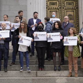 Varios diputados posan a las puertas del Congreso de los Diputados con carteles con fotos de Pablo González y la etiqueta #FreePablo este 30 de marzo de 2022.