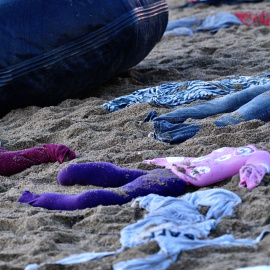 Varias prendas de ropa durante una acción de Open Arms, en la playa de la Barceloneta