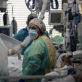 Dos sanitarios atienden a un paciente en la Unidad de Cuidados Intensivos (UCI) dedicada a enfermos de coronavirus del Hospital Universitario Ramón y Cajal, en Madrid (España), a 8 de octubre de 2020.