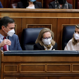 El presidente del Gobierno, Pedro Sánchez, conversa con la vicepresidenta segunda y ministra de Trabajo, Yolanda Díaz (d), en presencia de  (i) junto con la vicepresidenta primera y ministra de Asuntos Económicos, Nadia Calviño (c)  durante la sesión