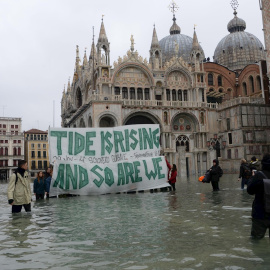 Varias personas sujetan una pancarta en la que se lee "La  marea está subiendo y así estamos". EFE/Andrea Merola