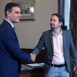 12/112019.- El presidente del Gobierno español en funciones, Pedro Sánchez y el líder de Podemos, Pablo Iglesias, se estrechan la mano en el Congreso de los Diputados donde este martes firmaron un acuerdo para la formación de un Ejecutivo. EFE/Paco Ca