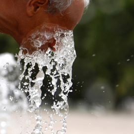 Un hombre se refresca en una de las fuentes de la ciudad de Córdoba para aliviar las altas temperaturas.