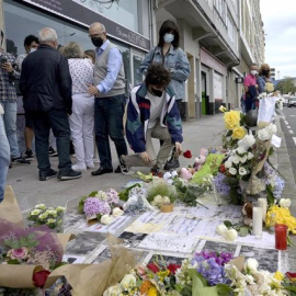 Un joven posa una rosa en el altar colocado en la acera donde fue golpeado Samuel.