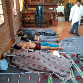 Un médico observa los cuerpos de cinco personas asesinadas durante los enfrentamientos entre la policía antidisturbios boliviana y los partidarios del ex presidente boliviano Evo Morales durante una protesta contra el gobierno interino en Sacaba, provin