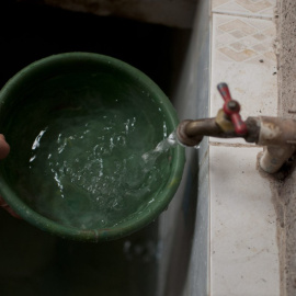Detalle de la mano de una persona sacando agua del grifo.
