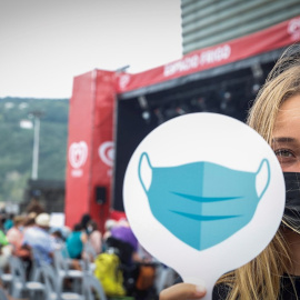 Una trabajadora del Festival de Jazz de San Sebastián, que abre este miércoles su 56 edición, recuerda a los asistentes las precauciones necesarias a causa de la covid.