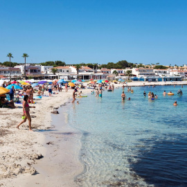 Decenas de personas disfrutan del sol en la playa de Punta Prima (Menorca).