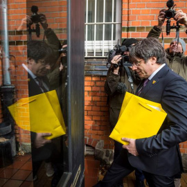Carles Puigdemont entra en la prisión de Neumünster (Alemania), donde estuvo detenido hace un año, para hacer una donación a la biblioteca de la institución. - EFE