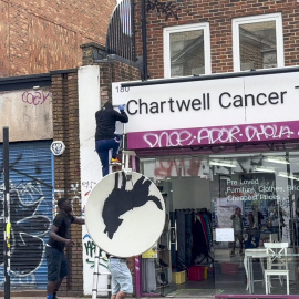 Imagen del momento en que tres personas robaban una obra de Banksy realizada en una antena parabólica.